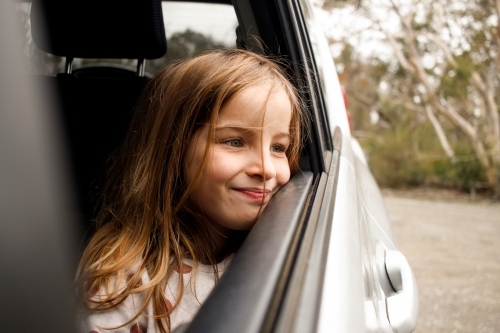 Girl traveling through country looking out car window