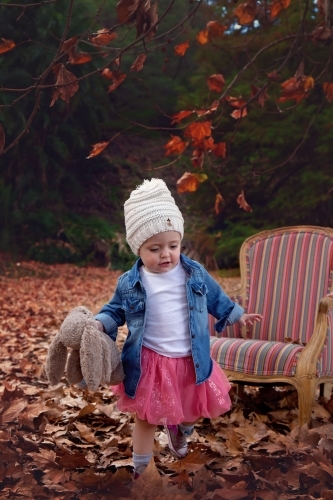 Girl With Hat Running in Autumn Leaves - Australian Stock Image