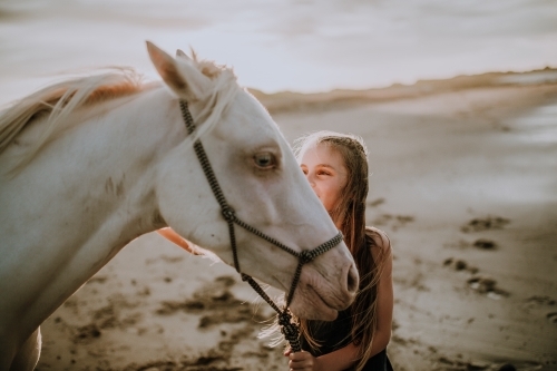 Girl with white horse on the beach at sunset - Australian Stock Image