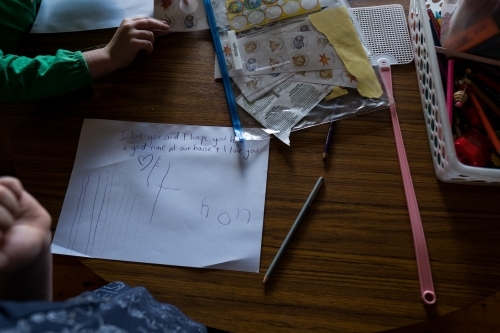 Girl working on schoolwork at table - Australian Stock Image