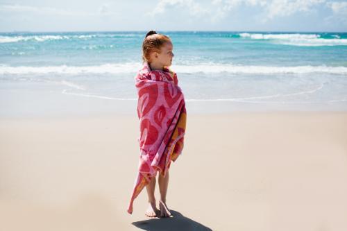 Girl wrapped in a towel at the beach - Australian Stock Image