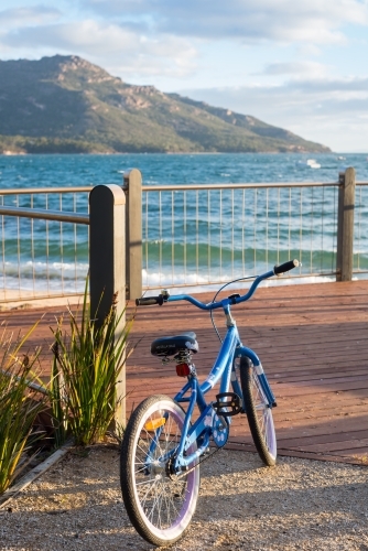 Girls bike standing on viewing deck near ocean and cliffs - Australian Stock Image
