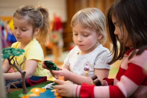 Girls playing with a plastic tree - Australian Stock Image