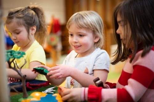 Girls playing with a plastic tree - Australian Stock Image