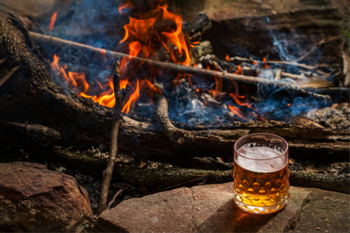 Glass of beer in front of an open fire - Australian Stock Image