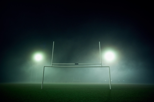 Goal posts on a sports oval in the fog at night - Australian Stock Image