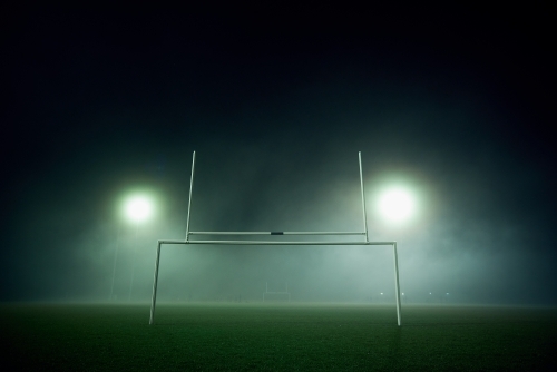 Goal posts on a sports oval in the fog at night
