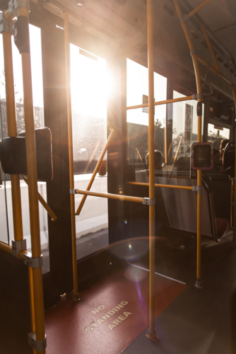 golden afternoon light streaming through the rear doors of a bus - Australian Stock Image