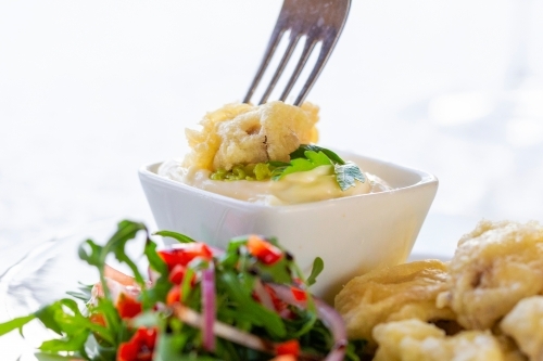 Golden-brown battered and fried meat with fresh salad and dip on the side. - Australian Stock Image
