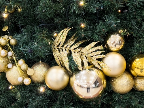 Golden decorations on a christmas tree with reflection and golden leaf - Australian Stock Image
