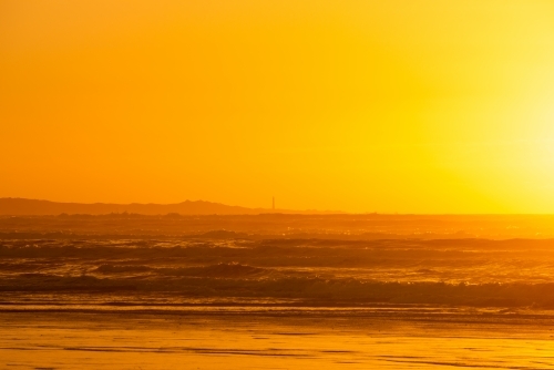 Golden Seascape with lighthouse in the distance - Australian Stock Image
