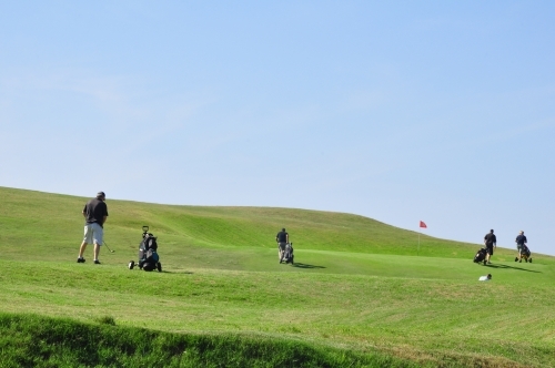 Golfers on green with blue sky - Australian Stock Image