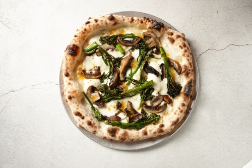 Gourmet wood fired mushroom pizza on table - Australian Stock Image