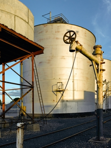 Grain silos and water pipe on a railway track in the country - Australian Stock Image
