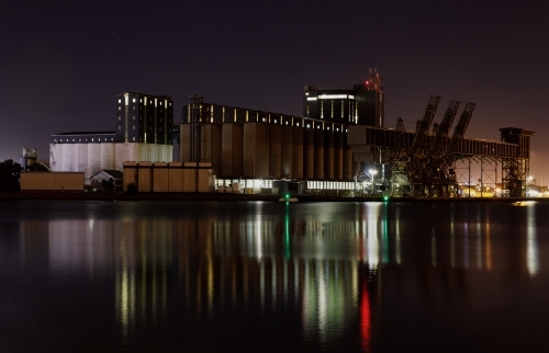 Carrington silos at night with lights reflected in water - Australian Stock Image
