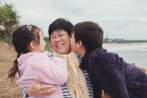 Grandchildren kissing their grandmother - Australian Stock Image