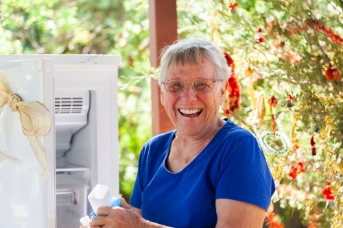 Grandma opening Christmas gift of fridge - Australian Stock Image