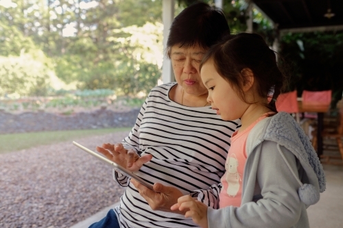 Grandmother and granddaughter using tablet - Australian Stock Image