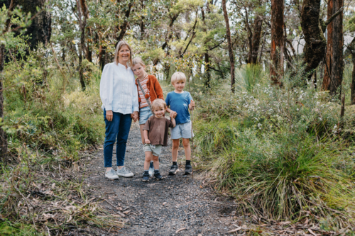Grandmother enjoying Australian Bushland with her Grandchildren standing on path together - Australian Stock Image