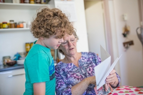 Grandmother reading card to grandson - Australian Stock Image