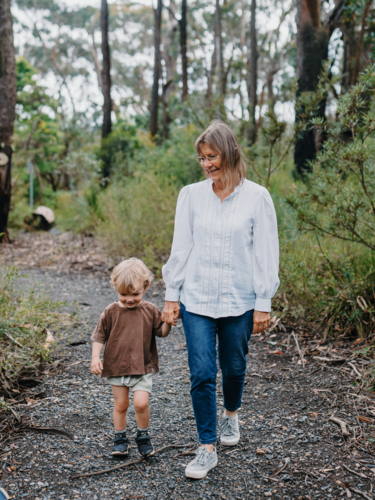 Grandmother spending time with grandson in nature walking along path together - Australian Stock Image