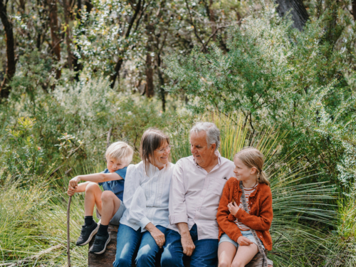 Grandparents enjoying Australian Bushland with their Grandchildren sitting together - Australian Stock Image