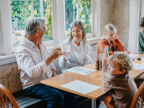 Grandparents enjoying lunch with their young grandchildren - Australian Stock Image