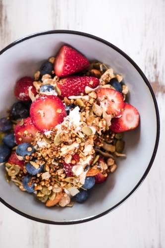 Granola and fruit in a bowl from above.