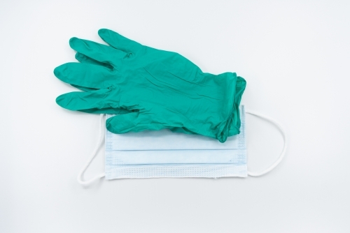 Green gloves and surgical mask flatlay - Australian Stock Image