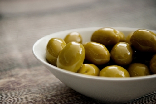 Green Olives In A Bowl on Wood - Australian Stock Image