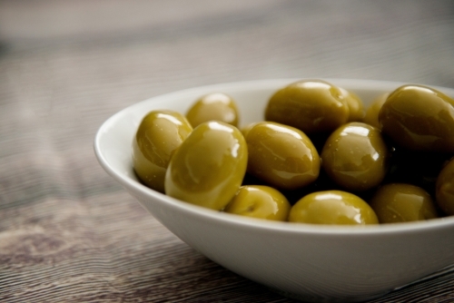 Green Olives In A Bowl on Wood