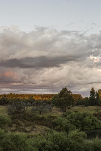 Grey clouds at sunset over river - Australian Stock Image