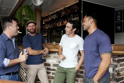 Group of mates having a drink at local craft beer bar - Australian Stock Image