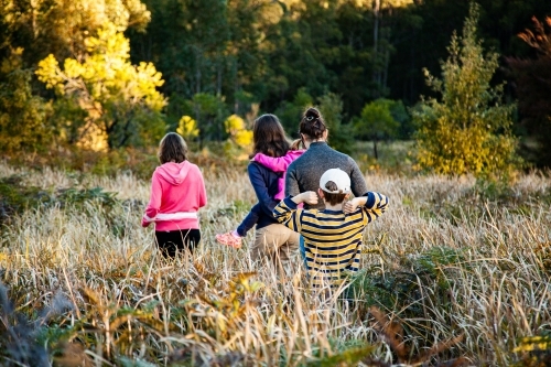 Group of teens and children bushwalking - going on a bear hunt - Australian Stock Image