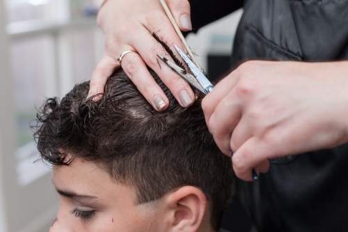 hairdresser cutting teenage boys hair
