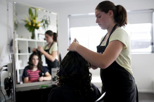 Hairdresser styling a woman's hair - Australian Stock Image