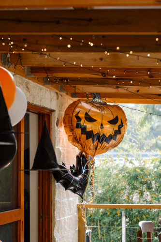 Halloween setup featuring an oversized jack-o’-lantern balloon surrounded black and orange balloons - Australian Stock Image