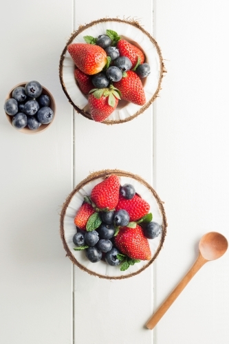 Halved coconuts filled with berries - Australian Stock Image