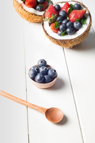 Halved coconuts filled with berries - Australian Stock Image