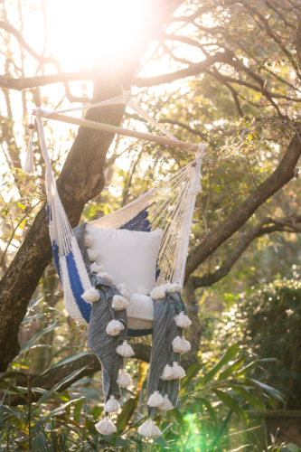 Hammock seat hanging from a tree with cushions and blankets - Australian Stock Image