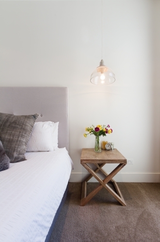 Hamptons styled bedside table with hanging pendant light in luxury home - Australian Stock Image