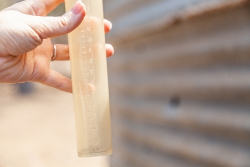 Hand holding empty rain gauge drought concept - Australian Stock Image