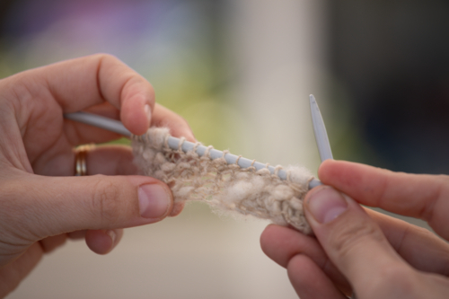 Hands displaying a small piece of knitting - Australian Stock Image