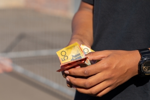hands holding a variety of polymer notes as cash - Australian Stock Image