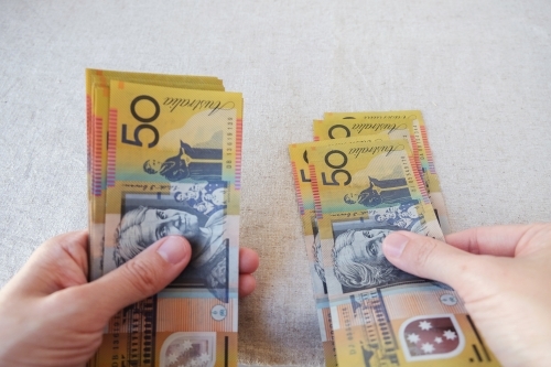 Hands holding fifty dollar notes, Australian money - Australian Stock Image