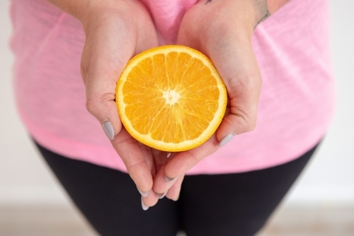 hands holding orange half healthy snack
