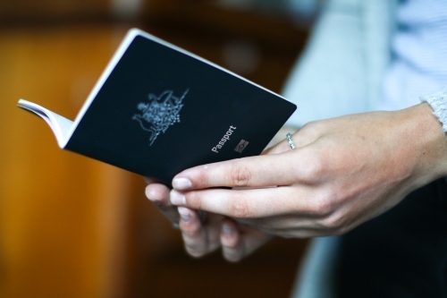 Hands of a young woman holding an Australian passport - Australian Stock Image