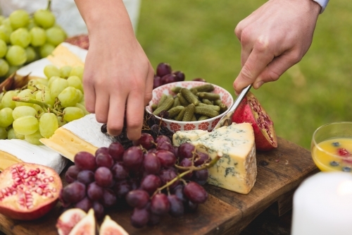 Hands picking food off antipasto platter - Australian Stock Image