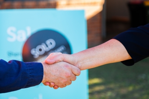Handshake in agreement and congratulations on house purchase and sale - Australian Stock Image