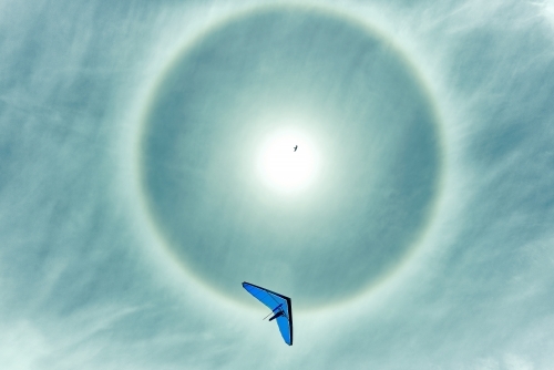 Hang gliding with sun halo on a beautiful day - Australian Stock Image